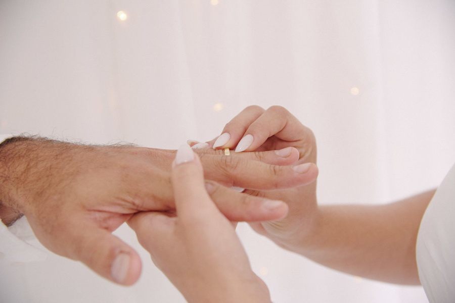Fotografia de casamento civil em SJC: detalhe em close das mãos de Gabrielle colocando a aliança no noivo Luiz Carlos. O registro foca na delicadeza do gesto e no simbolismo da união oficial em São José dos Campos.