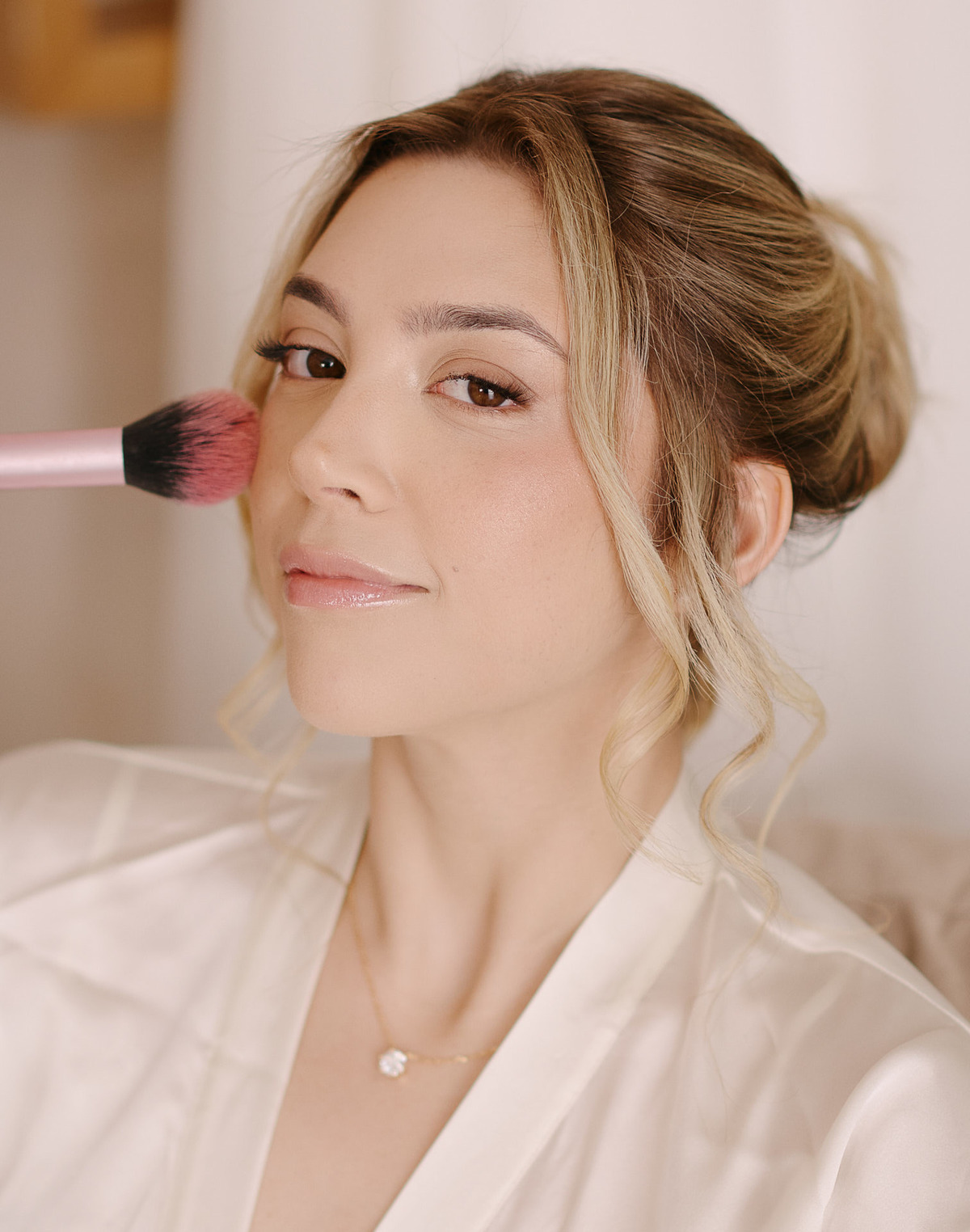 A Arte do Making of da Noiva em SJC. O olhar do profissional e a confiança da noiva. Fotografia de casamento em São José dos Campos que registra a equipe e a atmosfera do dia.