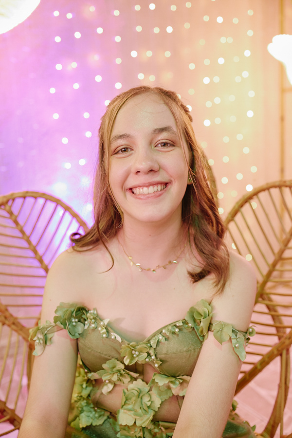 Close de Anna Clara sorrindo radiante em sua festa de 15 anos. A fotografia documental em Jacareí destaca a felicidade genuína e a sensibilidade da debutante, emoldurada por luzes suaves que refletem a atmosfera artística e mágica da celebração.