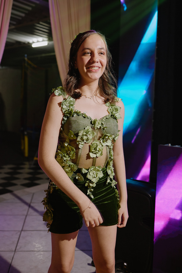 Anna Clara sorri radiante na pista de dança em seu traje artístico de festa. O registro documental em Jacareí destaca a alegria e a leveza da debutante, capturando sua essência vibrante sob as luzes coloridas da celebração de seus 15 anos.