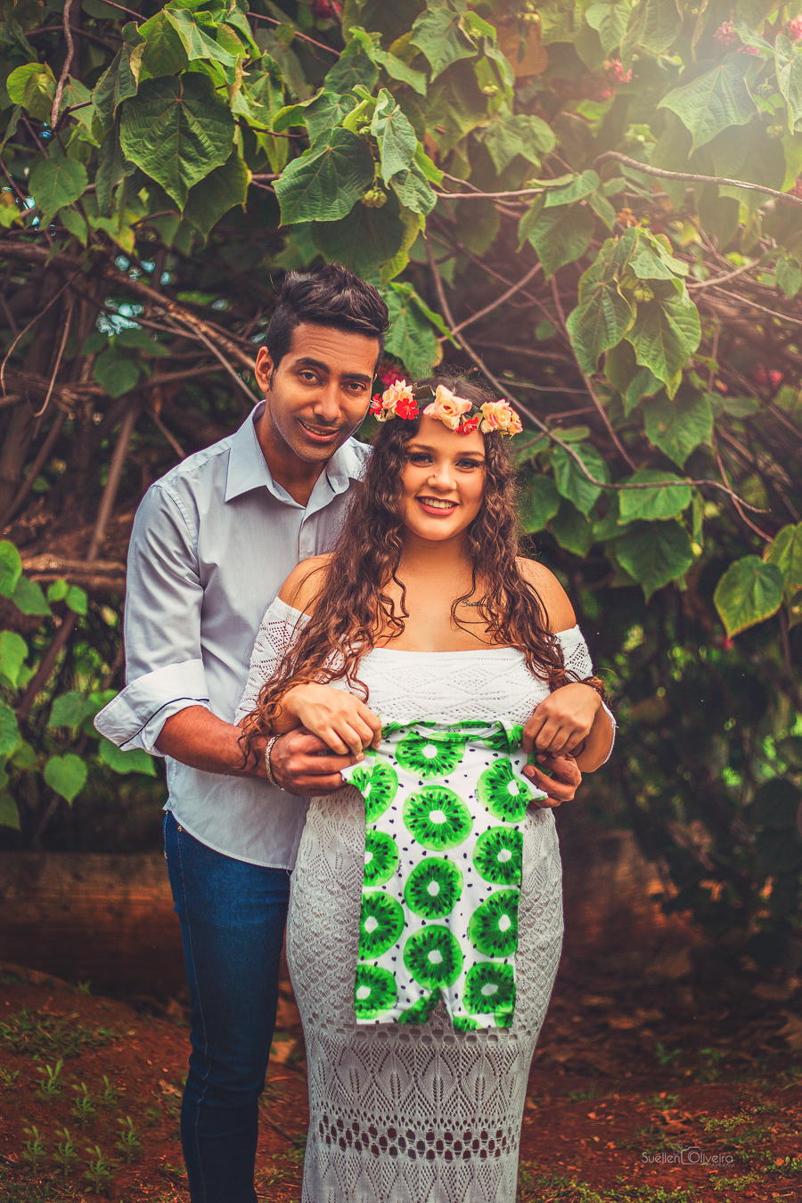 casal segurando a roupa do bebê