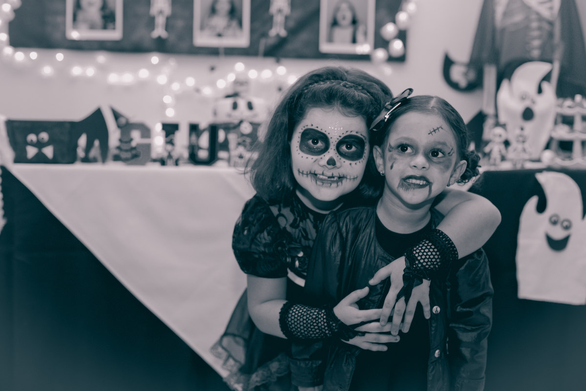 Giullia abraçada com a amiguinha menor, que também veio á caráter, em sua festa de aniversário. Foto em P/B.