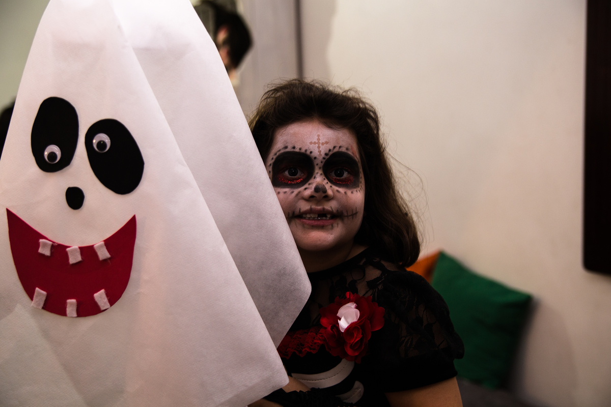 Giullia posando atrás de um dos enfeites feitos para a sua festa de aniversário, com o tema de terror.
