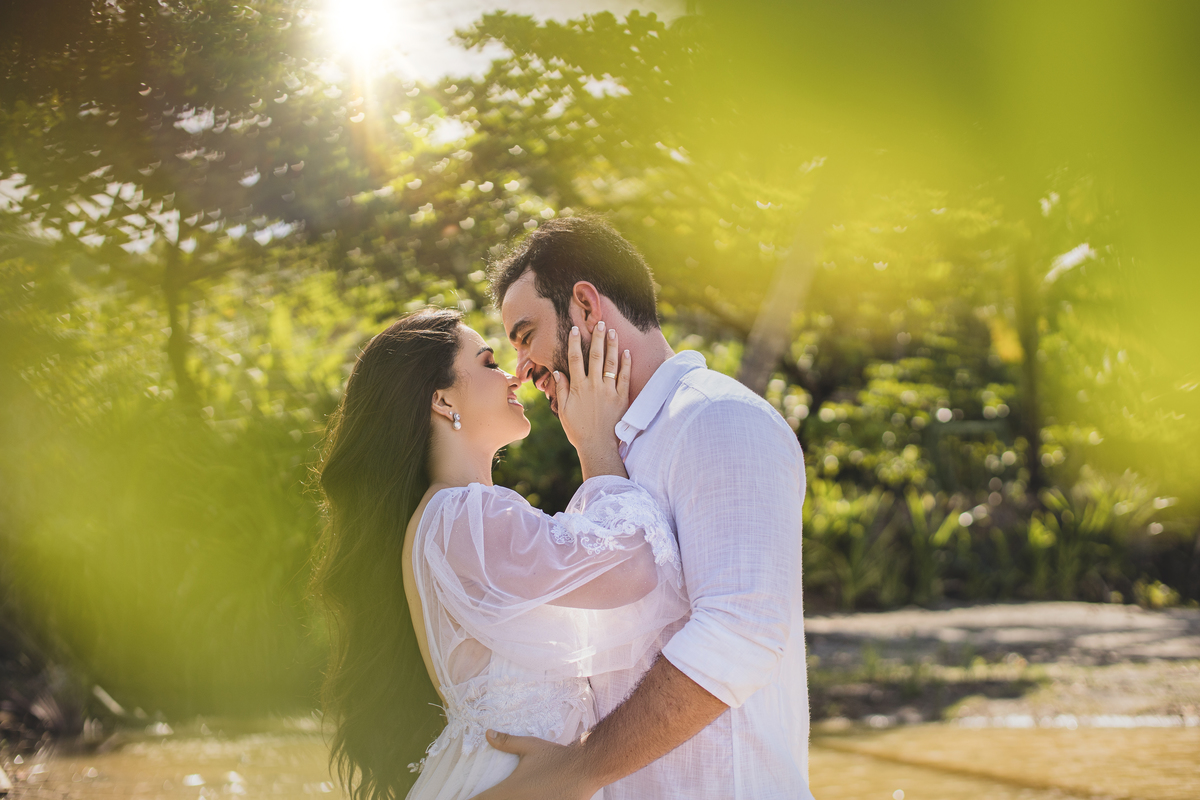 vestidos de branco e fazendo ensaio em praia para o casamento