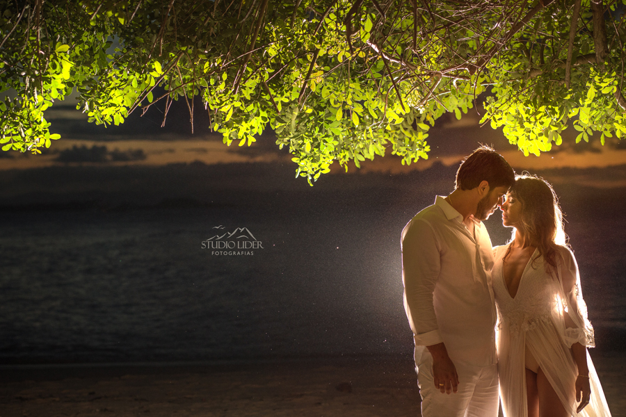 ensaio de casal na praiavestida de branco, vestido, noiva, flor no cabelo, casal, ensaio de casamento