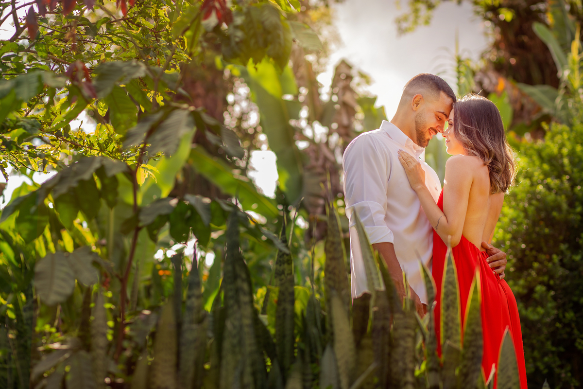 ensaio com roupa vermelha usando folhas verdes e feito em fazenda ensaio de casal 