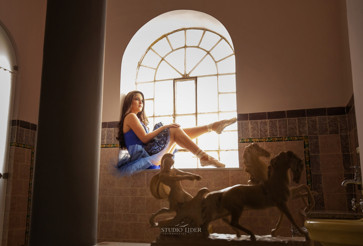 retrato de debutante com 15 anos roupa azul sorriso e olhos marcador em saio em Salvador 