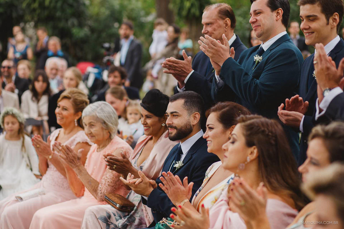 Padrinhos e madrinhas aplaudindo os noivos em cerimônia de casamento