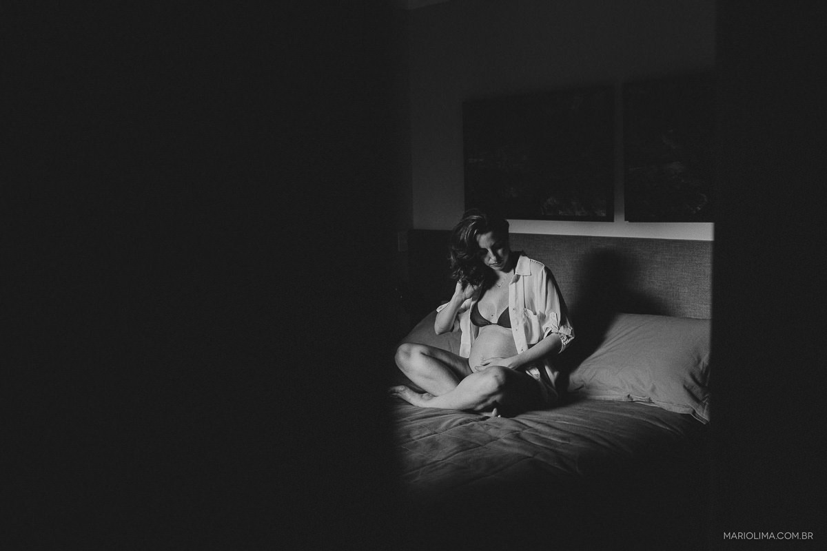 Gravida olhando para a barriga sentada na cama