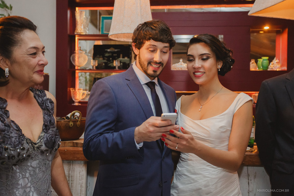 Noivos olhando o celular na Casa Marakuthai