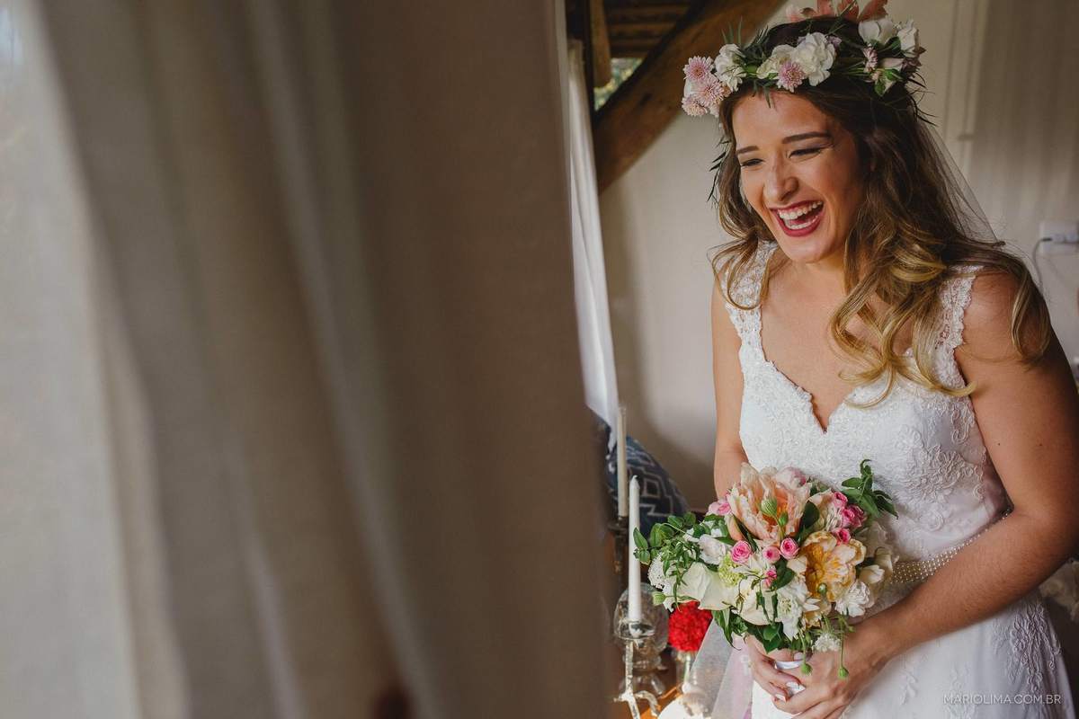 Fotografia de noiva emocionada se olhando no espelho com vestido feito por Camila Macedo e bouquet feito por Dizendo Sim
