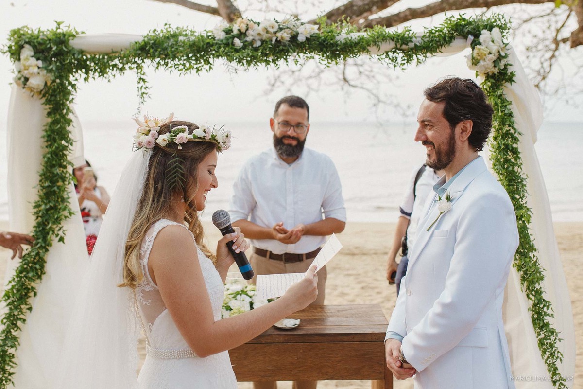 Noiva fazendo votos para o noivo em cerimônia na praia de Ilha Bela na Vila Salga