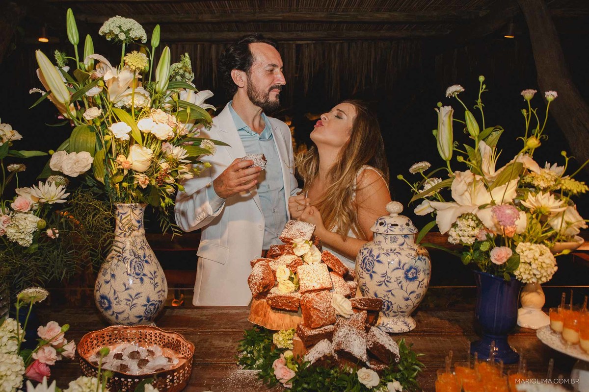 Brinde dos noivos na mesa do bolo decorada por Dizendo Sim em festa de casamento