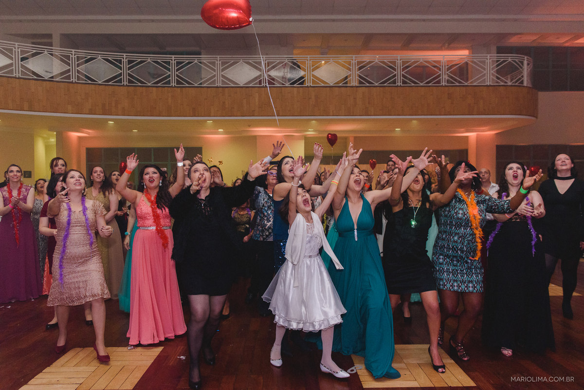 Madrinhas e convidadas tentando pegar o bouquet jogado pela noiva em Clube Primeiro de Maio