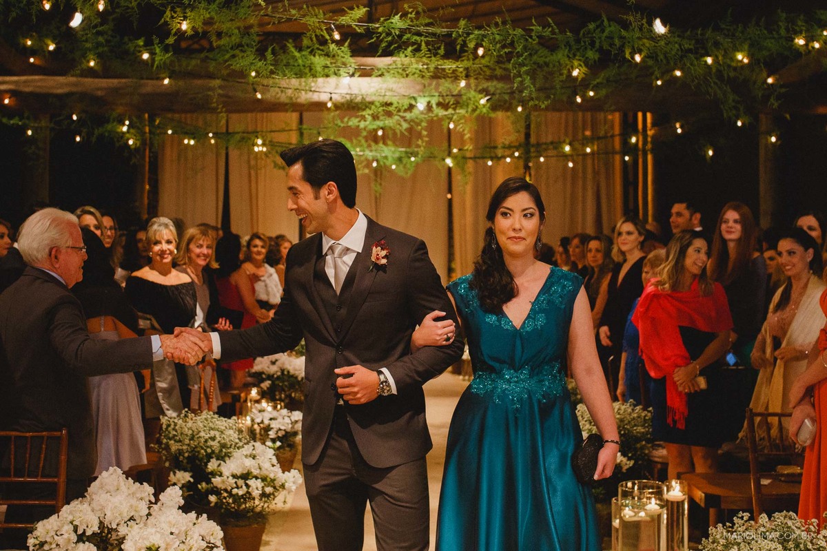 Fotografia de noivo entrando no Espaço Gardens com a mãe e cumprimentando os convidados ao redor