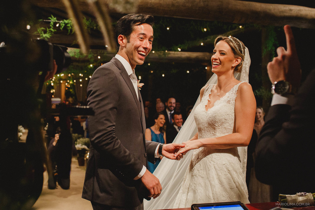 Retrato de noivos dando risada em cerimonia de casamento junto com o celebrante no Espaço Gardens