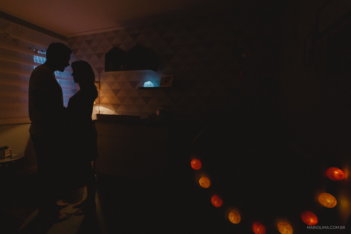 Pais de mãos dadas, se olhando no quarto do bebê