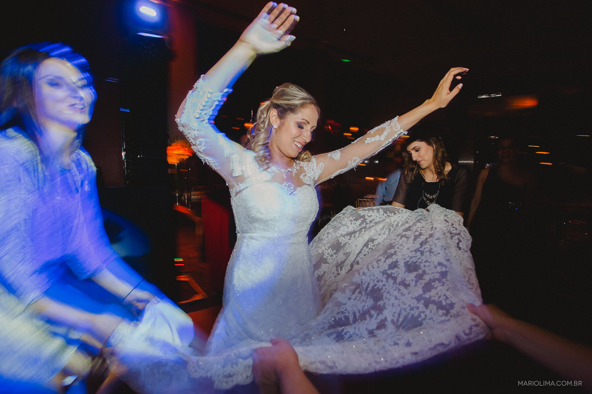 Noiva dançando com os braços pra cima em festa de casamento no Padrinhos e convidados observando os noivos em Hotel Hyatt
