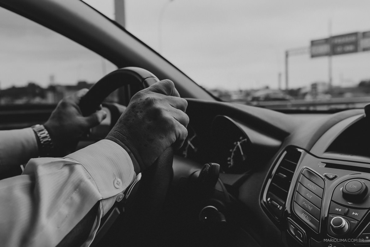 Mãos do pai da noiva dirigindo o carro em São Paulo