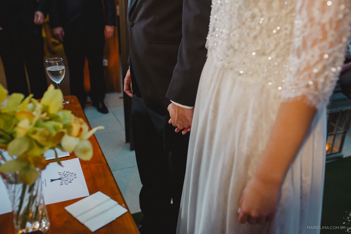 Noivos de mãos dadas em cerimônia de casamento no Espaço Lilló