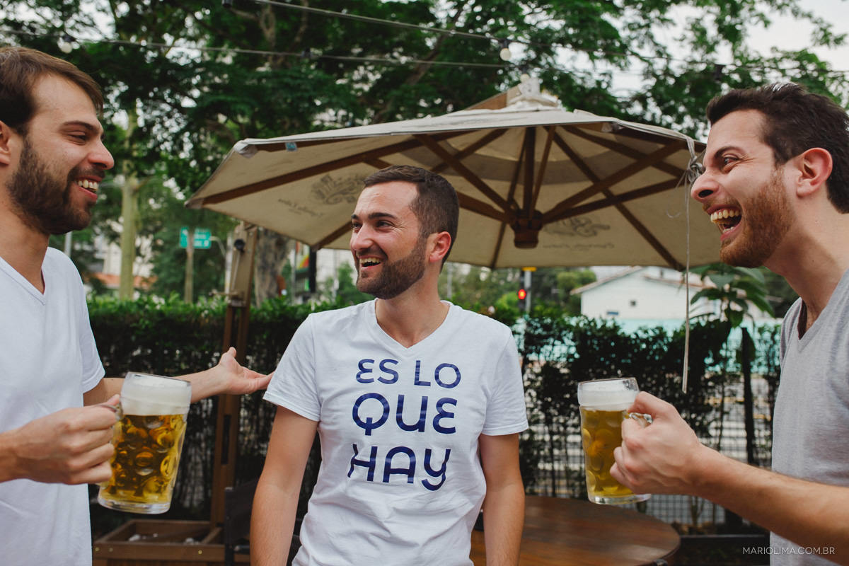 Fotografia de noivo rindo e tomando cerveja com os padrinhos