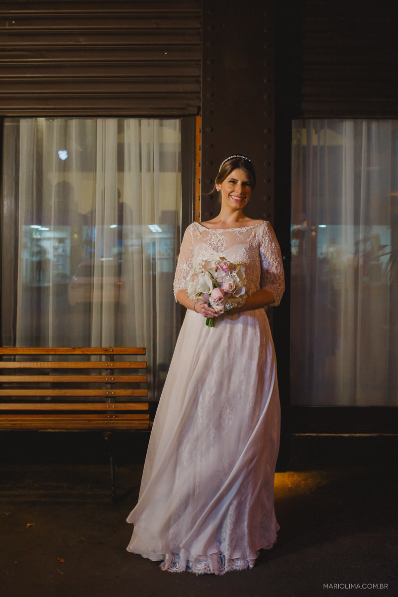 Fotografia de noiva em frente ao Espaço Lilló segurando bouquet feito por : Fernando (Floricultura Margarida)