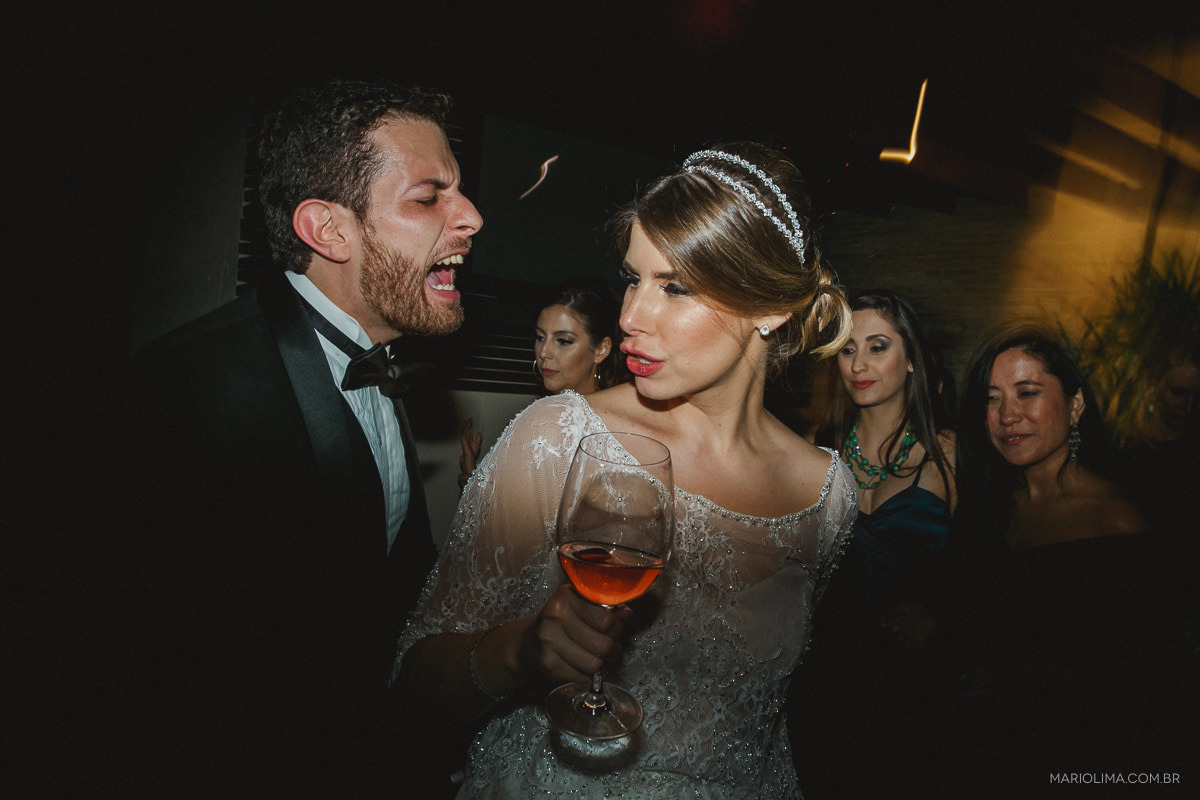 Noivo cantando e noiva bebendo champagne em festa de casamento no Espaço Lilló