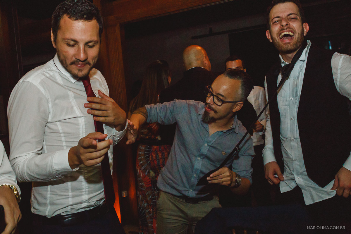 Padrinhos cortando a gravata do noivo em festa de casamento no Espaço Lilló