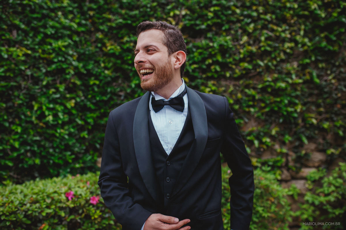 Noivo sorrindo e olhando para o lado em Espaço Lilló