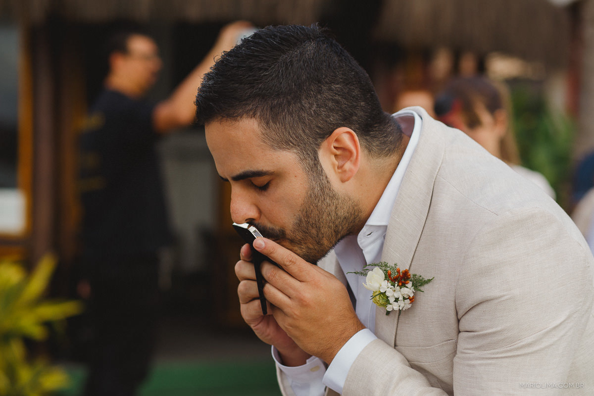 Noivo beijando fotografia de família em cerimônia de casamento em Vila das Velas