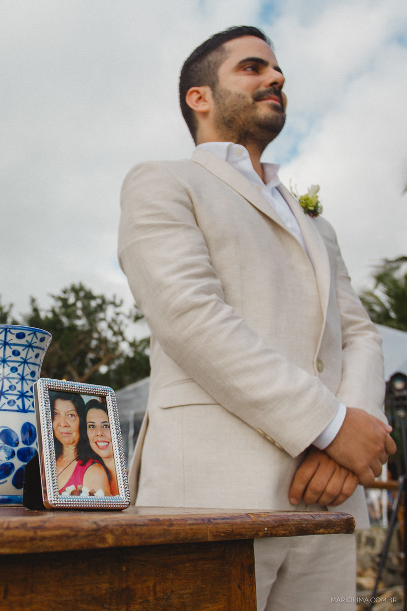 Noivo aguardando a entrada na noiva na cerimônia junto ao porta retrato de familia