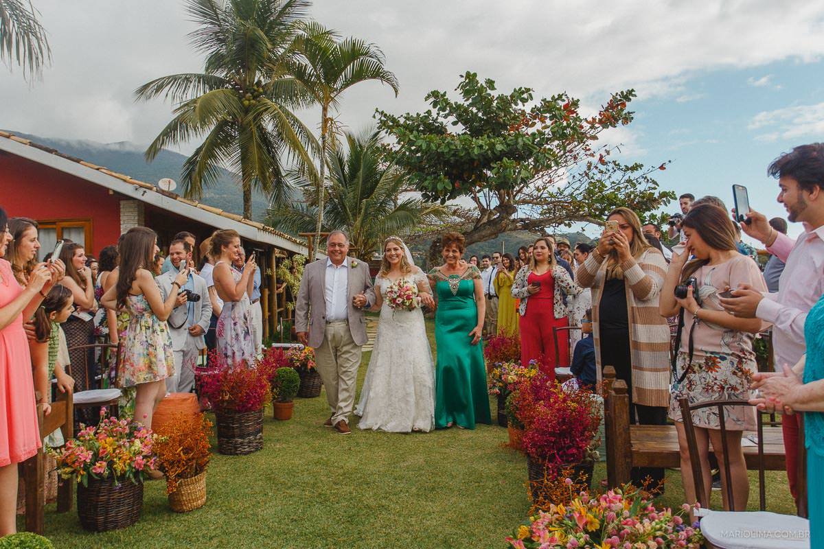 Noiva entrando com os pais em cerimônia de casamento na Vila das Velas