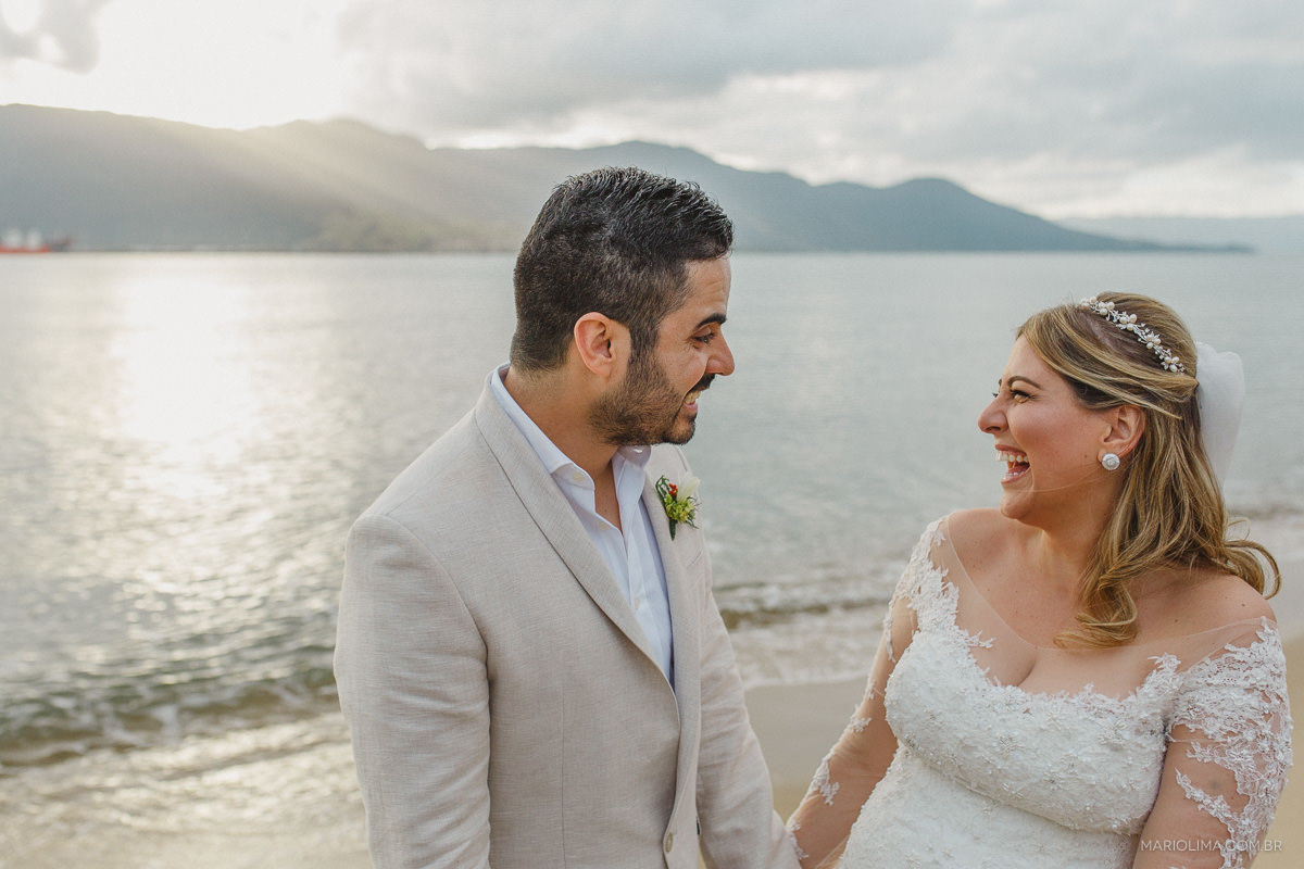 Noivos sorrindo em praia de Ilha Bela em Vila das Velas