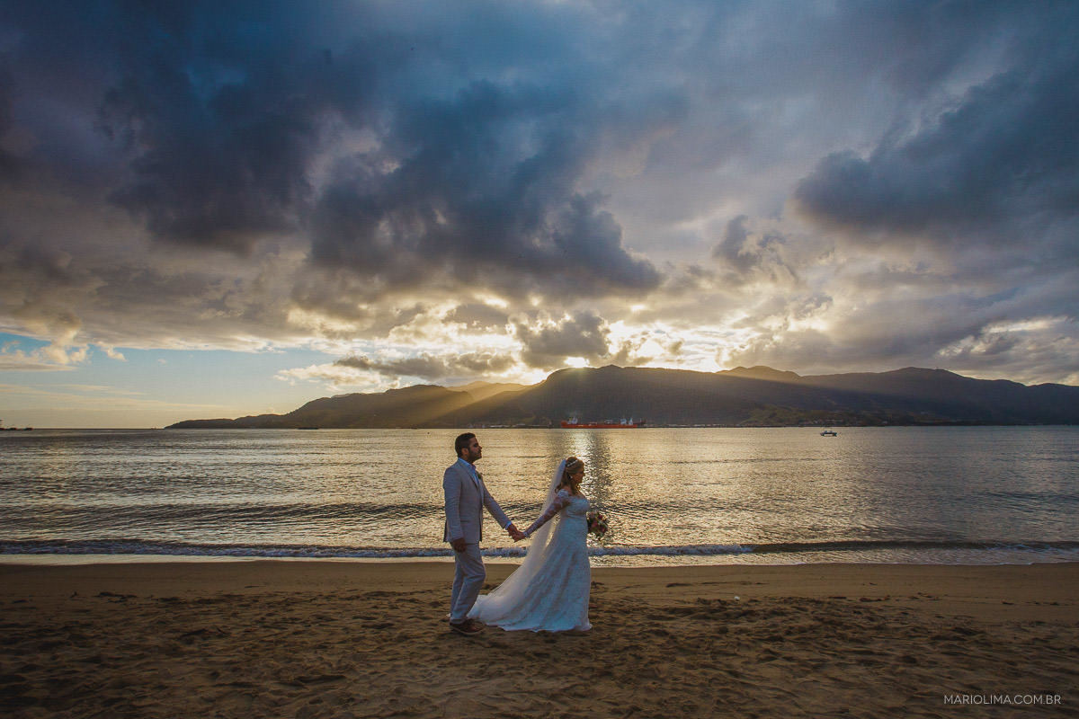 Fotografia de noivos caminhando na praia de Ilha Bela em Vila das Velas