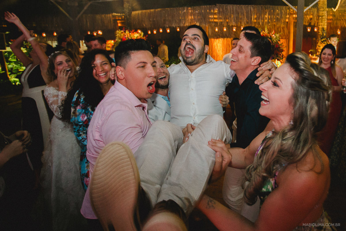 Noivo sendo carregado por padrinhos em festa de casamento na Pousada Vila das Velas