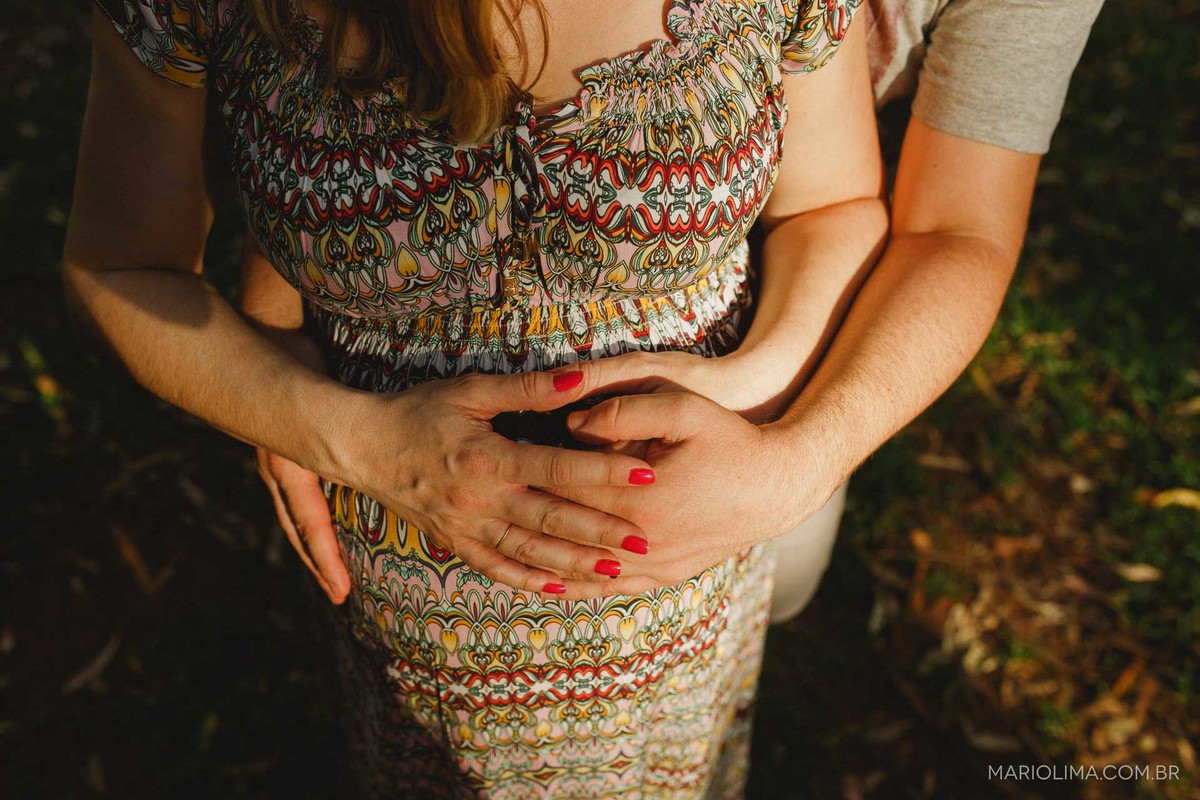 Fotografia de barriga de grávida abraçada pelos pais