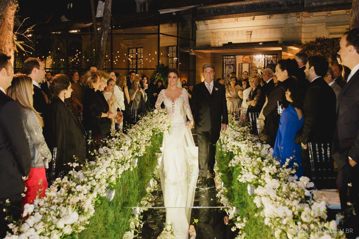 Noiva entrando com o pai em cerimônia de casamento no Iate Clube de Santos em Higienópolis