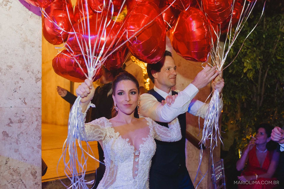 Noivos carregando balões de coração