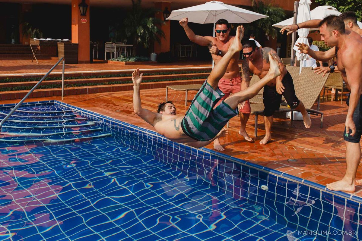 Amigos jogando o noivo na piscina do clube