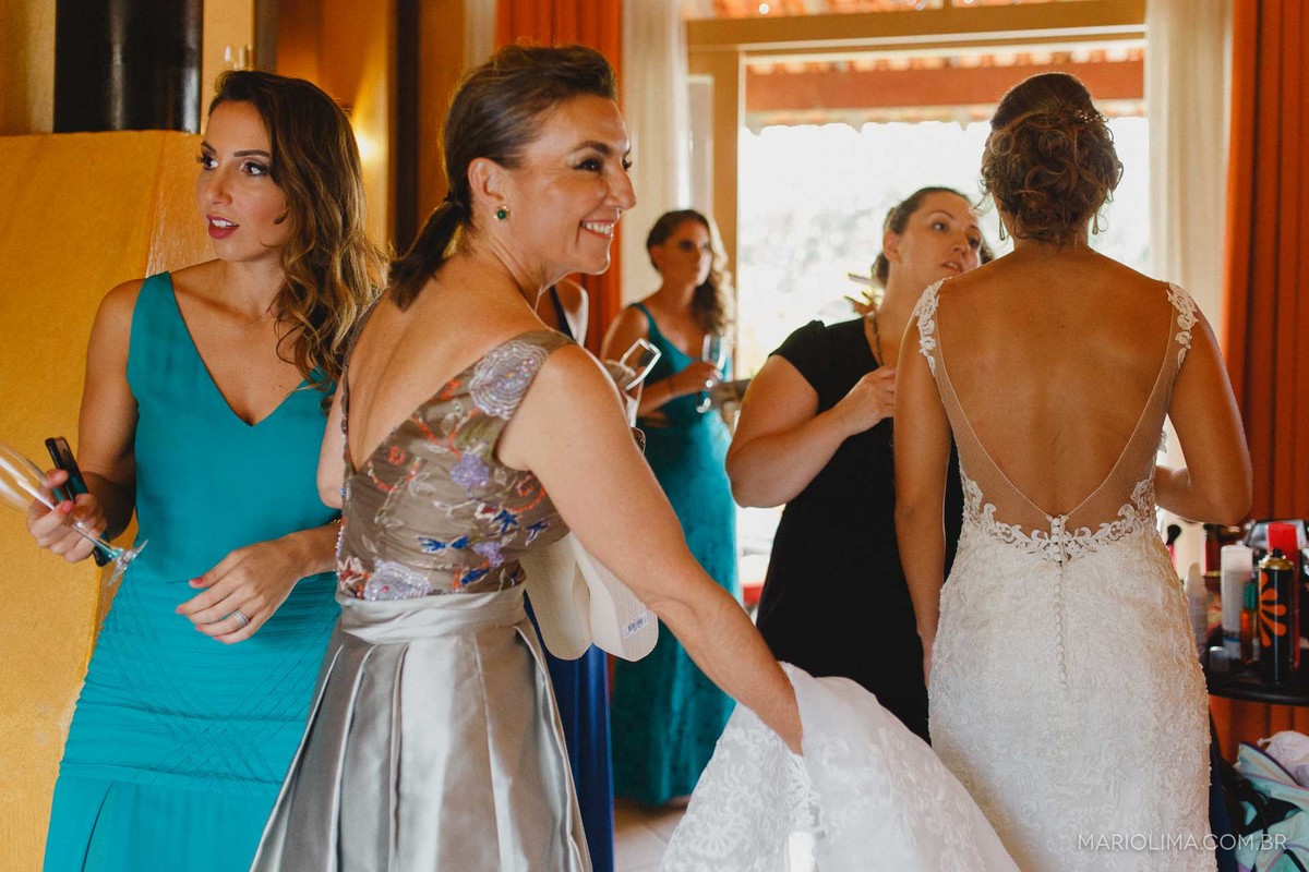 Fotografia de madrinha carregando o vestido da noiva