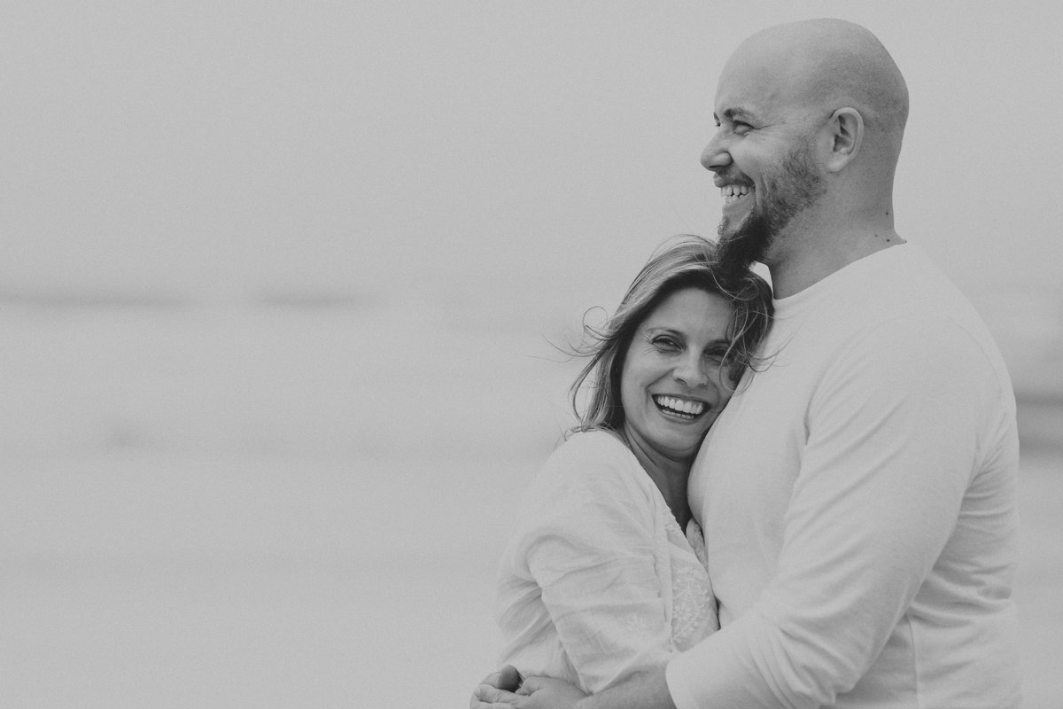 Fotografia de casal abraçado na praia
