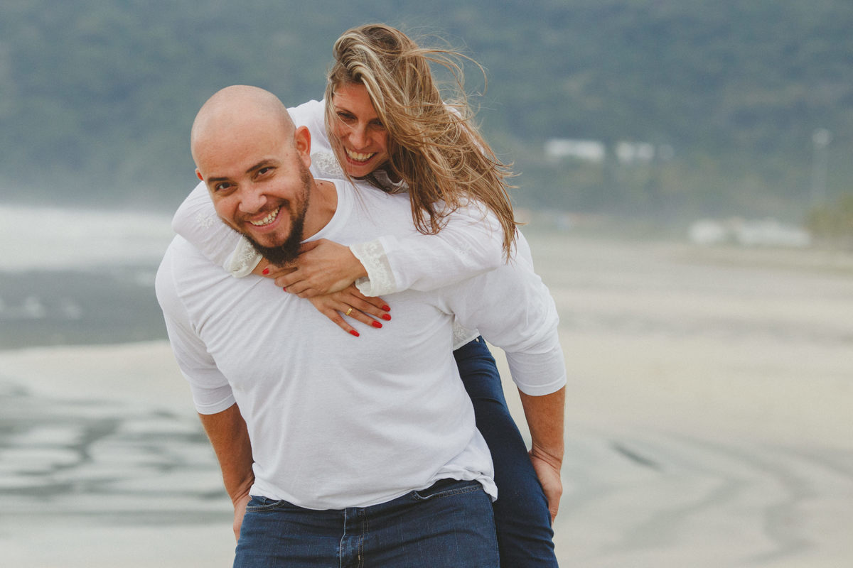 Retrato de homem carregando mulher no colo na praia