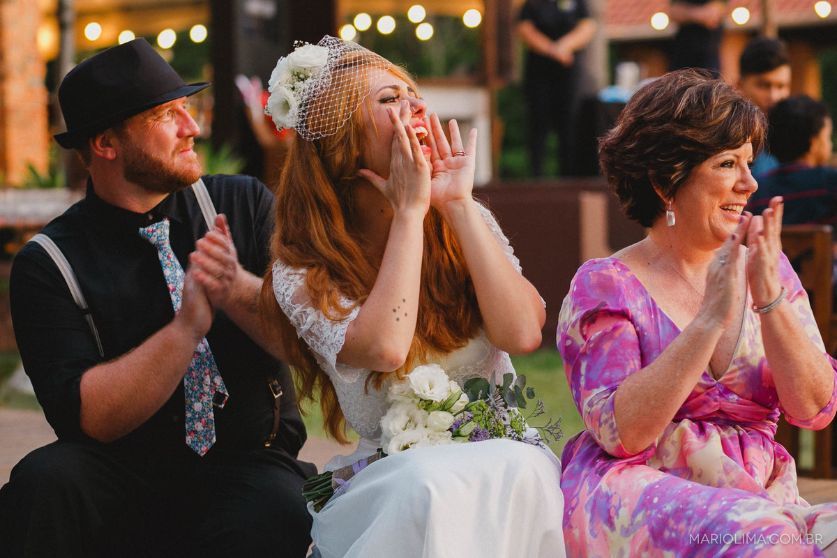 Noivos e mãe aplaudindo em Quinta dos Ipês 