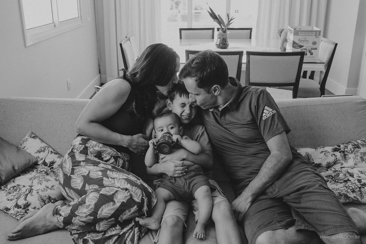 Fotografia de familia sentada no sofá da sala