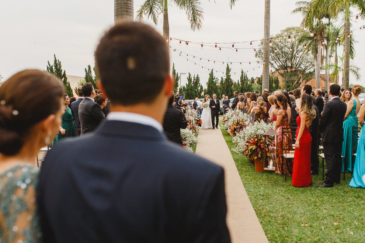 Noivo olhando a entrada da noiva em Buffet O Casarão Catanduva 