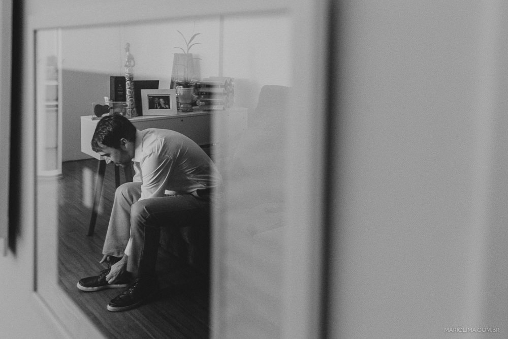 Fotografia de noivo calçando sapato 