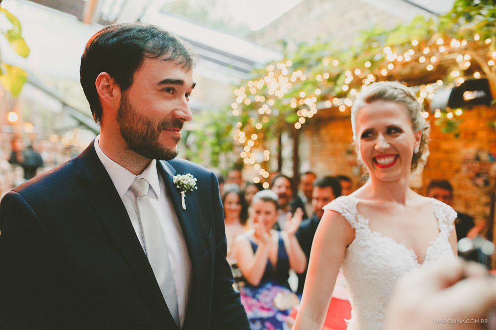Noiva sorrindo olhando para o noivo em cerimônia de casamento no Espaço Quintal