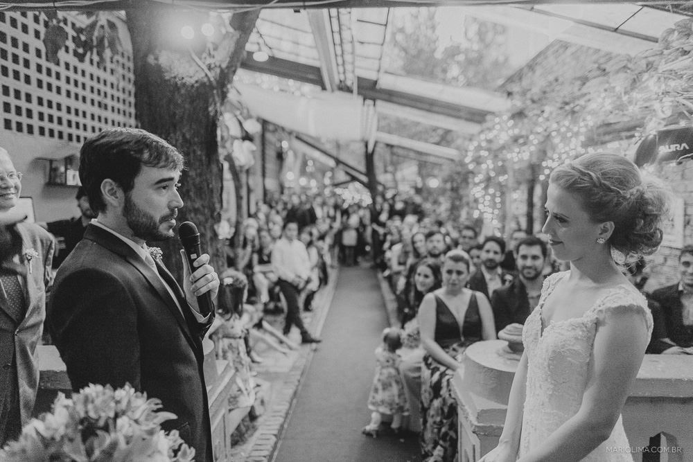 Noiva emocionada ao ouvir os votos do noivo em cerimônia de casamento no Espaço Quintal