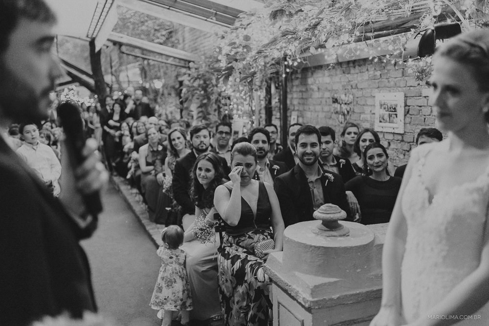 Convidados emocionados com os votos do noivo em cerimônia de casamento no Espaço Quintal