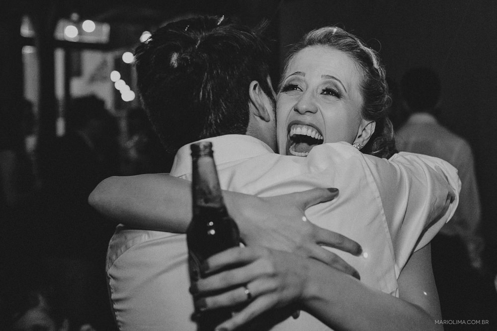 Noiva abraçando o noivo e bebendo em festa de casamento no Espaço Quintal